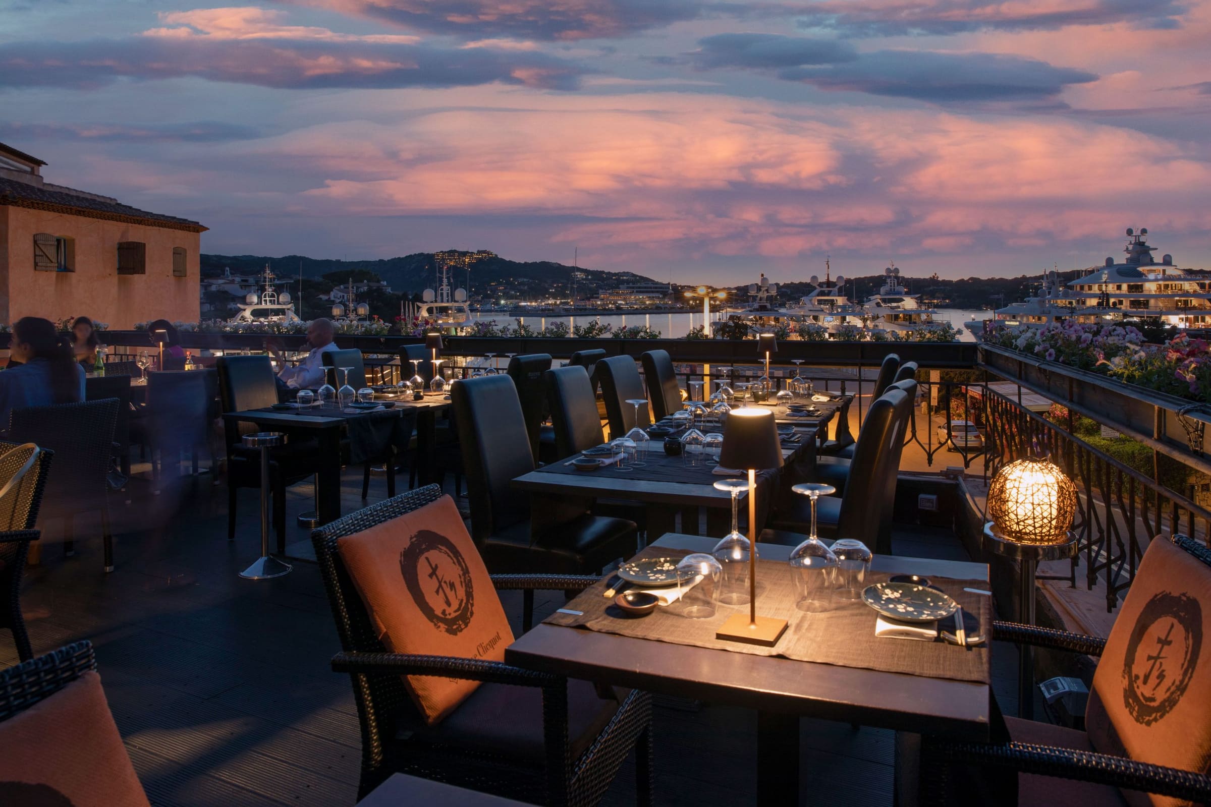Vista del ristorante con tavoli all'aperto, ambientazione al tramonto a Porto Cervo.