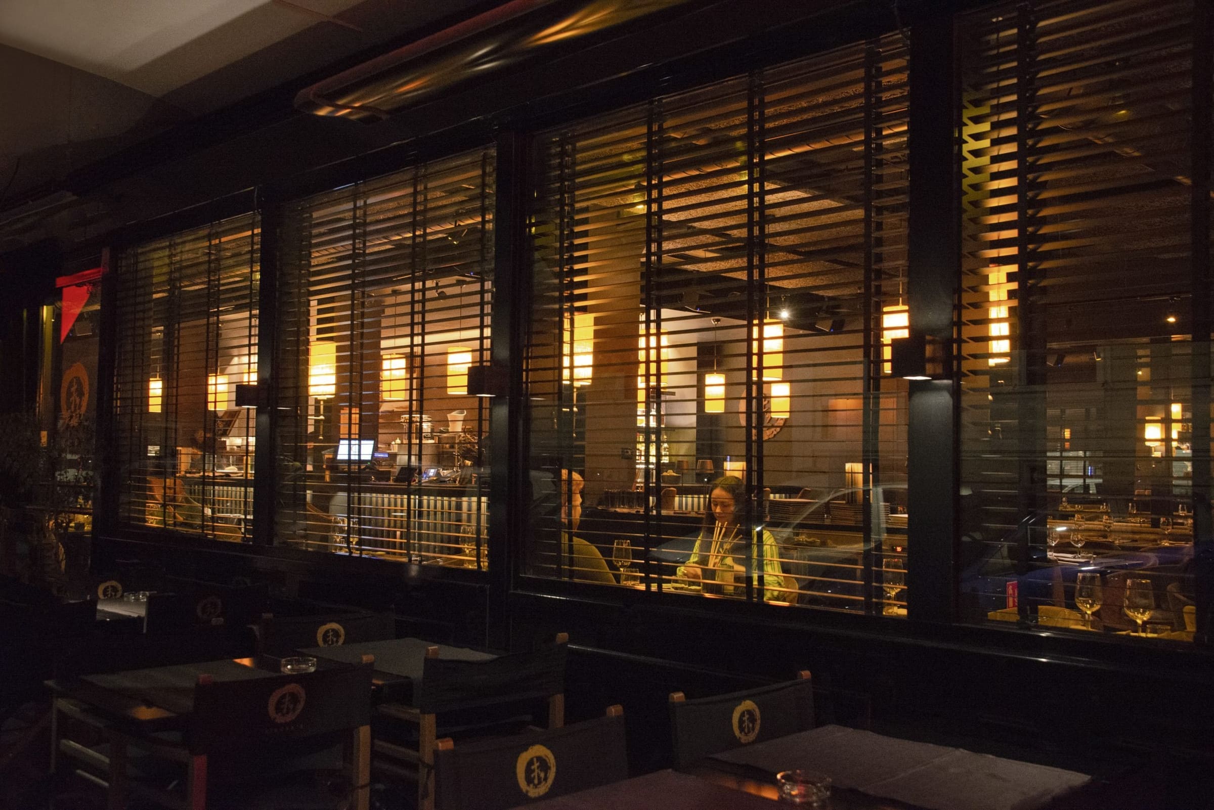Interno di un ristorante visto dall'esterno con vetrate