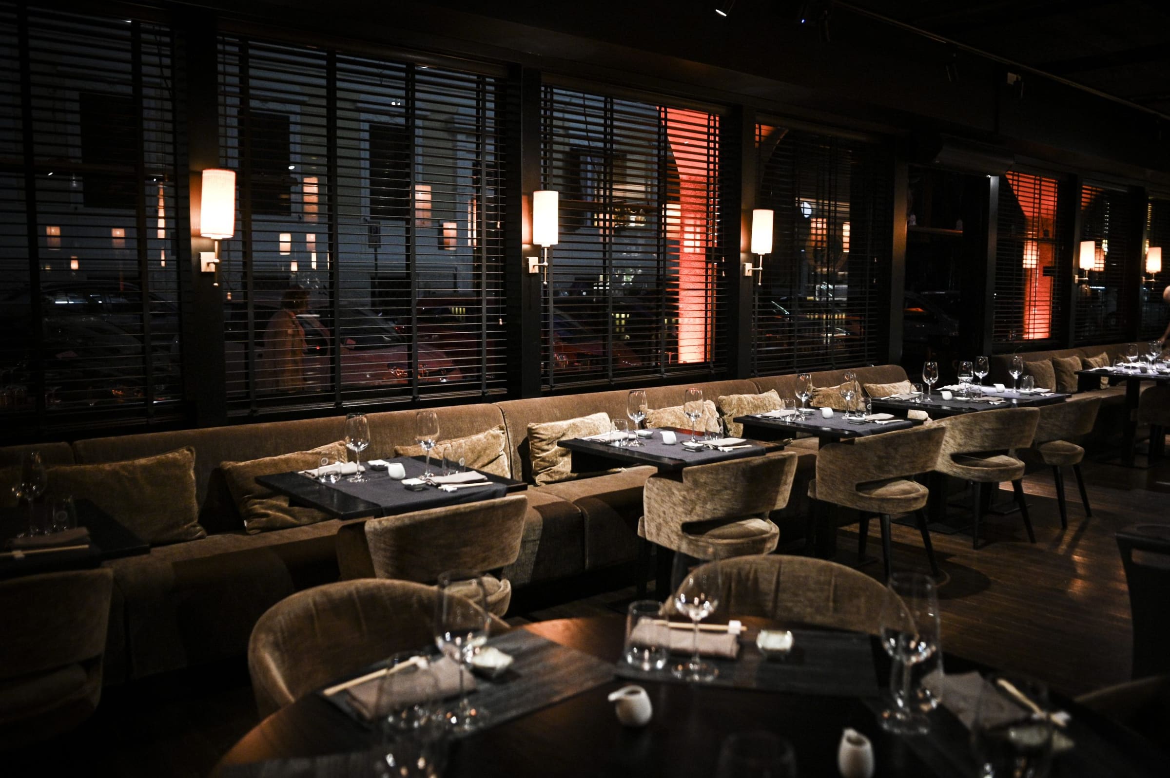 Interno di un elegante ristorante con tavoli apparecchiati e illuminazione soffusa.